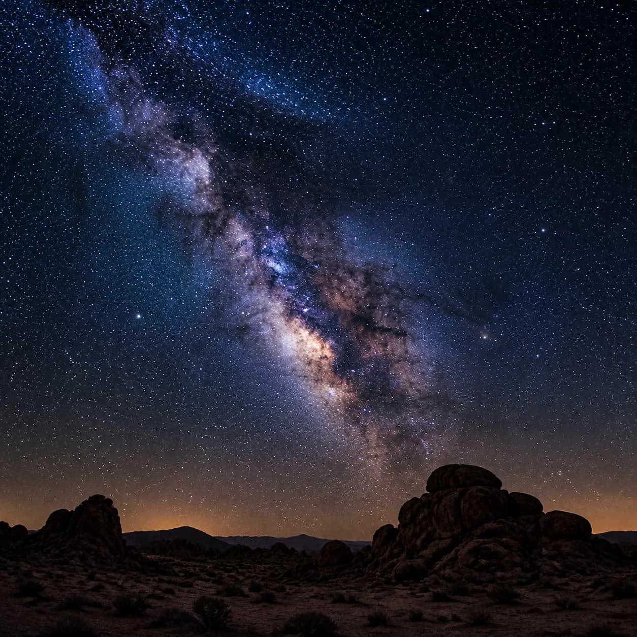 Astrophotography example with a bright Milky Way over a dark desert landscape.
