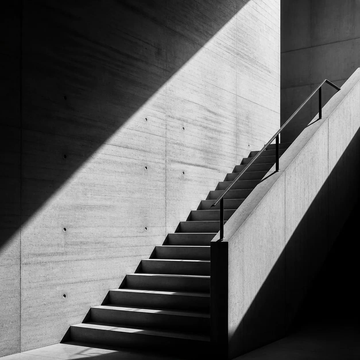 Black and white photography example of architectural stairs in strong shadow.